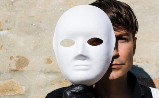 Uomo che indossa una maschera, simbolo del narcisismo e delle fragilità nascoste dietro l’apparenza