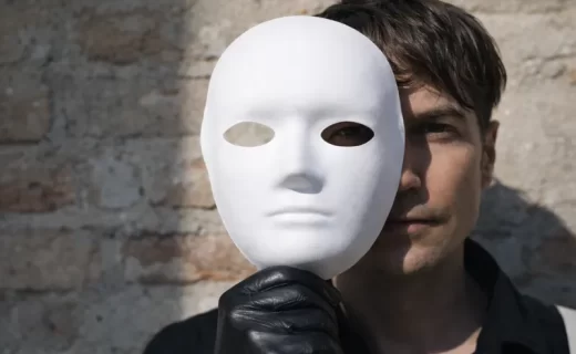 Uomo che indossa una maschera, simbolo del narcisismo e delle fragilità nascoste dietro l’apparenza